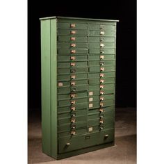 an old green filing cabinet with lots of drawers on it's front and sides