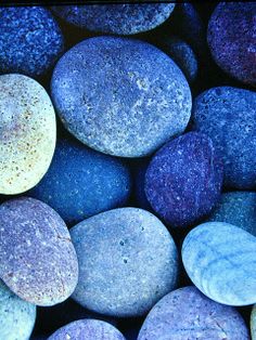 many different colored rocks are arranged in a pattern on top of each other, including blue and purple