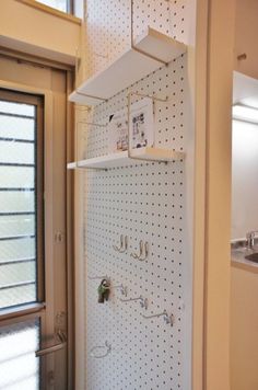 a white pegboard wall in a kitchen next to a sink