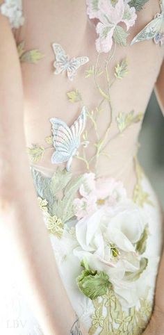 the back of a woman's dress with flowers and butterflies on it