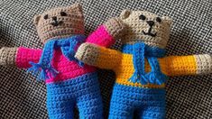 two crocheted teddy bears laying on top of a couch