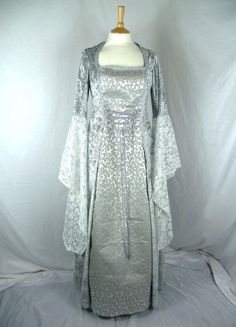 This listing is for a custom made dress,it will be made to the measurements you send me. Please send me a message with your bust,waist and hip measurements,and please measure from the top of your shoulder to the floor with shoes on. It will be made with beautiful silver crushed velvet and stunning grey embroidered bridal brocade. The sleeves are part velvet with a stunning pale silver embroidered lace .It has a corset style front and back with lacing so you can adjust the dress to fit your body Fitted Gothic Gown For Fancy Dress, Gothic Fitted Gown For Fancy Dress, Fitted Princess Dress With Corset Back, Fitted Gothic Ball Gown, Medieval Wedding Dress With Fitted Bodice, Elven Style Wedding Dress With Historical Design, Elven Wedding Dress With Historical Design, Fantasy Style Floor-length Wedding Dress, Fantasy Floor-length Wedding Dress