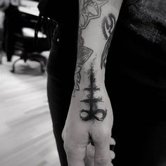 a person with a tattoo on their arm holding up a hand that has an anchor in it