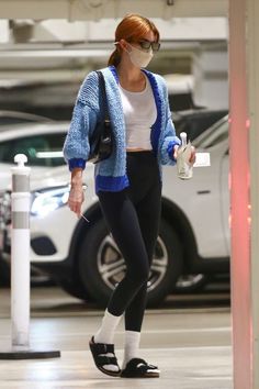 a woman in black and white is walking through an airport