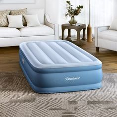 an inflatable mattress is sitting on the floor next to a couch and chair