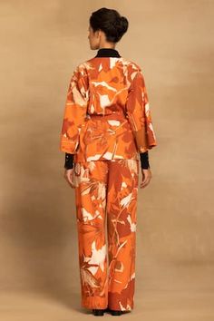 Rust kimono features monochrome floral print in cotton twill base. Comes with coordinating pant.
Components: 2
Pattern: Printed
Type Of Work: Floral
Neckline: V Neck
Sleeve Type: Three Quarter
Fabric: 100% Cotton Twill
Color: Orange
Other Details: 
Length:
Shirt: 29 inches
Pant: 42 inches
Model height: 5feet 9inches, wearing size S
Approx. product weight: 200 gms
Note: Belt and inner black t-shirt worn by the model is not for sale
Occasion: Party,Work - Aza Fashions Floral Print Sets For Workwear In Fall, Floral Print Cotton Sets For Workwear, Spring Workwear Kimono With Kimono Sleeves, Spring Workwear Kimono, Festive Orange Floral Print Sets, Orange Printed Cotton Set, Traditional V-neck Floral Print Kaftan, Cotton V-neck Kaftan With Floral Print, Cotton V-neck Printed Kimono