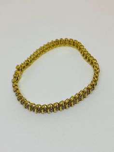 "This is a traditional, vintage 10K yellow gold and diamond tennis bracelet. Material(s) 10K yellow gold + (100) diamonds - measuring 1.5 mm each (approx. 1.5 carats total weight) (There are two diamonds per cluster, and 50 clusters, equaling 100 diamonds total.) Measurements: This bracelet measures 7 inches in length and 6.5 millimeters in width. Weight: 11.4 grams Markings: \"10K\" If you have any questions about this bracelet, please do not hesitate to contact us! ♥" Vintage Diamond Tennis Bracelet With Single Cut Diamonds, Vintage Tennis Bracelet With Single Cut Diamonds, Vintage Round Brilliant Cut Diamond Bracelet, Vintage Tennis Bracelet With Brilliant Cut For Anniversary, Vintage Brilliant Cut Tennis Bracelet For Anniversary, Vintage Tennis Bracelet With Diamond Accents, Vintage Gold Diamond Bracelet With Single Cut Diamonds, Vintage Yellow Gold Diamond Bracelet With Single Cut Diamonds, Yellow Gold Tennis Bracelet With Diamond Accents For Anniversary