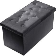 a large black ottoman with buttons on the top and bottom part, sitting in front of a white background