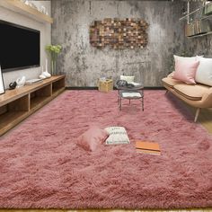 a living room filled with furniture and a flat screen tv mounted on a wall next to a pink rug