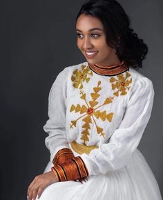 A stunning Habesha kemis that features a luxurious Menen fabric and intricate brown and yellow tilf designs. Handmade by skilled artisans, this kemis is a true masterpiece that captures the essence of Ethiopian fashion. Crafted from high-quality Menen fabric, this dress is soft, lightweight, and comfortable to wear. The full-length silhouette is both elegant and modest, with a traditional Ethiopian neckline and sleeves. The kemis is adorned with intricate tilf designs in warm brown and yellow co Festive Habesha Kemis With Traditional Patterns, Fitted Habesha Kemis With Traditional Patterns For Ceremonies, Habesha Kemis For Eid With Traditional Patterns, Habesha Kemis For Traditional Ceremonies During Eid, Eid Habesha Kemis For Traditional Ceremonies, Traditional Embroidered Habesha Kemis For Wedding, Ceremonial Habesha Kemis For Eid With Traditional Patterns, Traditional White Fitted Habesha Kemis, Ceremonial Habesha Kemis With Traditional Patterns