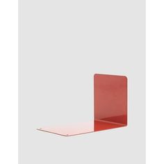 an empty red shelf with a white wall in the background