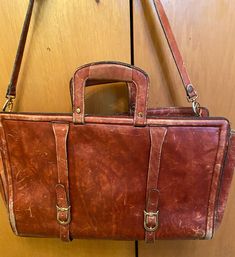 Not sure of its age. I'm guessing the seventies era. In spite of exterior marks on its thick leather it has a lot of years of use left in it. Tons of character! See photos for measurements and condition. Leather strap shows very little wear and handles are solid. Some marks show interiorly. Zipper in nice condition also. This is a quality bag as evidenced by its years of use and continues to be very usable and has a charm all its own!! Vintage Laptop Bag With Luggage Sleeve For Travel, Vintage Laptop Bag With Luggage Sleeve For Daily Use, Vintage Rectangular Briefcase For Business Trips, Vintage Formal Briefcase With Luggage Sleeve, Vintage Satchel Laptop Bag With Luggage Sleeve, Vintage Leather Lined Laptop Bag For Travel, Vintage Rectangular Laptop Bag For Formal Use, Vintage Briefcase With Leather Lining, Vintage Briefcase With Leather Lining For Daily Use