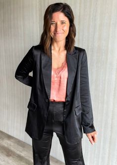 Achieve a modern and polished look with our stylish Black Satin Blazer. This one-button blazer features long sleeves and a sleek satin finish for a classic yet contemporary silhouette. Shown paired over our Terracotta Lace Cami with the Black Satin Pants. Material: 96% Polyester, 4% Spandex Model is wearing a Size Small. Black Satin Pants, Work Blazer, Satin Blazer, Satin Pants, Lace Cami, Blazer Buttons, Polished Look, Black Satin, Satin Finish