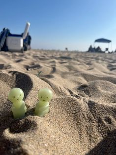 two small plastic ducks sitting in the sand