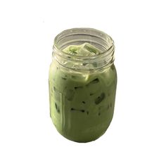 a jar filled with green liquid on top of a white surface