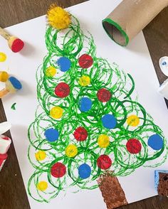 a child's drawing of a christmas tree on paper with crayons and glue