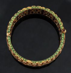 Presented is a superb 22 karat gold, diamond, and enamel bracelet. This piece was made in India, in a very traditional Mughal style. Considering that this style of jewelry has been popular for well over a century, we aren't sure of the age of this piece; it might be from the 1880s, or it could be a 20th century piece. Whatever the case, it is truly exceptional in terms of material and craftsmanship. The bracelet is a hinged wide bangle or cuff style, done in an openwork design. The exterior is s Luxury Meenakari Bracelets, Traditional Yellow Gold Ceremonial Bracelets, 22k Gold Meenakari Bangle Bracelet, Festive Yellow Gold Meenakari Bangle, Traditional Gold Enamel Bangle, Traditional 22k Gold Openable Bracelet, Traditional 22k Gold Bracelet For Ceremonial Occasions, Ceremonial Green Bracelets With Tilla Detail, Yellow Gold Kundan Bracelets With Meenakari