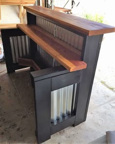 a wooden counter top sitting on top of a cement floor next to a wall mounted oven