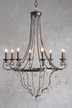 a chandelier hanging from the ceiling in a room with grey walls and flooring