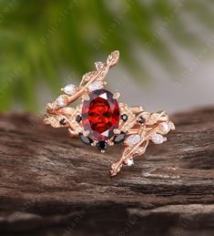 a close up view of a ring with a red stone and white diamonds on it