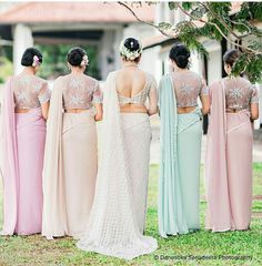 a group of women standing next to each other wearing different colored dresses and headpieces