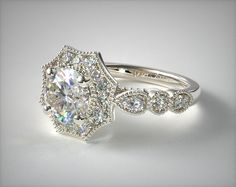 a diamond ring with an oval center surrounded by smaller round diamonds