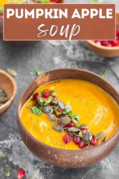 pumpkin apple soup in a wooden bowl with pomegranates on the side