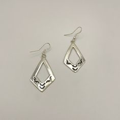 Stamped sterling silver dangle earrings featuring elegant French hook wires. Meticulously handcrafted by Navajo artist Pauline Nelson, these earrings showcase traditional artistry with a modern touch. Perfect for adding a unique, southwestern charm to your jewelry collection. Measurements: 2.4" x 0.9" (including wire)Weight: 0.26oz (7.43g)Material: Sterling silver (silver925) Ideal for both casual and formal wear, these earrings make a timeless addition to any wardrobe. Artisan Silver Dangle Jewelry, Silver Diamond-shaped Jewelry, Nickel-free Long Drop Sterling Silver Earrings, Artisan Sterling Silver Earrings, Sterling Silver Dangle Jewelry Stamped 925, Artisan Long Drop Pierced Jewelry, Nickel-free Sterling Silver Earrings, Stamped 925 Sterling Silver Drop Earrings, Artisan Sterling Silver Drop Earrings