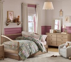 a child's bedroom with pink walls and floral bedding, dressers, chairs, and teddy bears