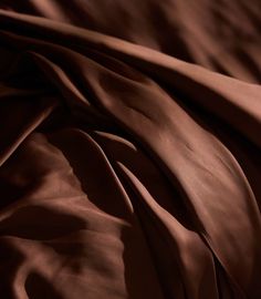 a close up view of a bed with brown sheets