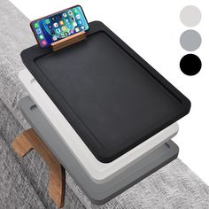 a cell phone is sitting on top of a tray that sits on a couch with two legs