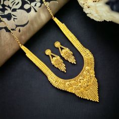 This exquisite gold-plated haram necklace set is a true testament to Indian craftsmanship. The intricate design, featuring delicate floral motifs and intricate detailing, exudes timeless elegance. The long, cascading necklace is complemented by matching earrings, creating a harmonious and luxurious ensemble. The rich gold plating adds a touch of opulence, making this set perfect for special occasions and festive celebrations. Set of include-: 1 Necklace 2 Piece Earrings 1 Necklace Back Dori/chai Luxury Gold Sets With Zari Weaving, Festive Gold Set With Pallu, Gold Traditional Wear With Intricate Design For Navratri, Gold Zari Weaving Jewelry For Weddings, Festive Gold Jewelry With Zari Weaving, Gold Wedding Jewelry With Zari Weaving, Gold Sets With Pallu For Navratri, Elegant Gold Sets For Navratri, Gold Sets With Pallu For Festivals