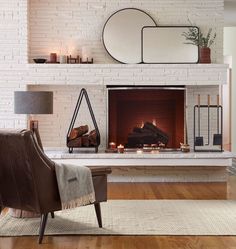 a living room with a fireplace and mirror above it