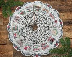 a white doily sitting on top of a wooden table next to pine needles and branches