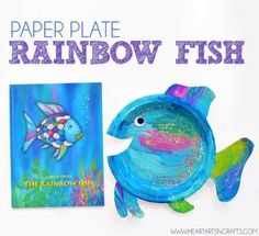 the paper plate rainbow fish is next to a children's book and its cover