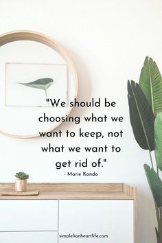 a plant sitting on top of a white dresser next to a wall with a quote from marie kondo