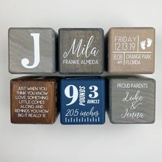 wooden blocks with names and date printed on the sides are arranged in a row to form a wall decoration