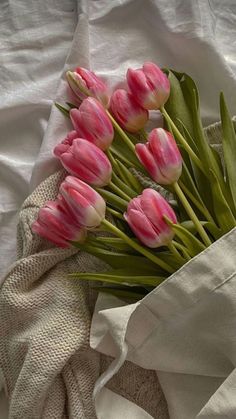 a bouquet of pink tulips sitting on top of a white cloth