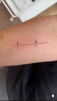 a man's arm with two birds on the same line