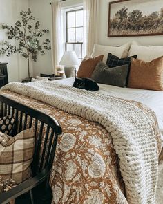 a bed sitting in a bedroom next to a window with a cat on top of it