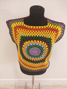 a crocheted top is displayed on a mannequin's head stand