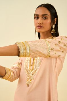 Rose pink kurta with gota patti work and highlighted with basra moti. Paired with dhoti pant.
Component: 2
Pattern: Embroidered
Type Of Work: Gota and Bead Work
Neckline: Mandarin
Sleeve Type: Long Sleeves
Fabric: Kurta - Silk Chanderi; Dhoti Pant - Bamberg Satin
Color: Pink
Other Details: 
Gota and bead work
Occasion: Wedding,Mehendi - Aza Fashions Pink Kurta, Chanderi Kurta, Dhoti Pants, Satin Color, Pink Shorts, Mandarin Collar, Festival Wear, Set For Women, Three Quarter Sleeves