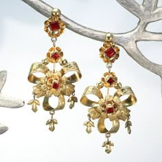 These late 19th century earrings were likely made in the Iberian peninsula. Hand crafted in gilded silver and set with bright red pastes, these beautiful danglers have wonderful movement when worn. They have screw backs but could be converted to posts on request. The bow and flower design is typical for earrings from this period and place.  These large and lovely earrings measure 59.5 mm north to south and 25.7 mm across, together they weigh 7.3 grams. Unmarked but carefully tested as silver.  I Mirror Palais Jewelry, Vintage Jewelry Design, Antique Drop Earrings With Historical Design, Historical Yellow Gold Drop Earrings, Yellow Gold Historical Drop Earrings, Yellow Gold Drop Earrings With Historical Design, Traditional Yellow Gold Earrings With Historical Design, Antique Earrings With Historical Design For Ceremonial Occasions, Victorian Style Ceremonial Earrings For Pierced Ears