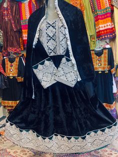 This stunning Afghani velvet frock is made of the finest silk velvet, and is embroidered with intricate white charmadozi designs. The charmadozi embroidery is a traditional Afghan technique that uses charma to create intricate patterns and designs. The frock is fully lined and has a fitted bodice with long sleeves. It falls to the ankles in a graceful A-line skirt. The frock is perfect for a special occasion, such as a wedding or a formal event. It is also a great choice for everyday wear, as it Black Dresses With Traditional Patterns For Eid, Black Dresses With Traditional Patterns For Festive Occasions, Black Festive Dresses With Traditional Patterns, Eid Dresses With Traditional Black Patterns, Festive Black Dresses With Traditional Patterns, Festive Black Dress With Traditional Patterns, Traditional Festive Winter Dresses, Traditional Winter Festive Dresses, Black Dresses With Intricate Embroidery For Festivals