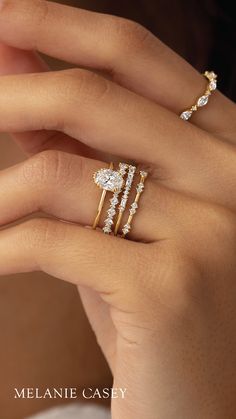 a woman's hand with three rings on her fingers and one ring in the middle