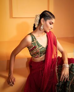 Introducing our striking Red Lehriya Drape Saree with Artsilk Bandhani and Shell detailing, accompanied by a Green Print Bandhani Blouse adorned with Shells and Fringes – a captivating ensemble that seamlessly merges traditional aesthetics with contemporary charm. Traditional Fitted Pre-draped Saree For Navratri, Traditional Blouse With Dupatta In Chinon, Anarkali Bandhani Print Saree For Party, Party Bandhani Print Blouse For Navratri, Party Bandhani Blouse Piece For Navratri, Bollywood Style Bandhani Print Blouse For Party, Festive Georgette Choli For Navratri, Party Saree With Bandhani Print, Bollywood Style Bandhani Print Choli For Festive Occasions