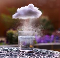 a cloud floating over a glass filled with water