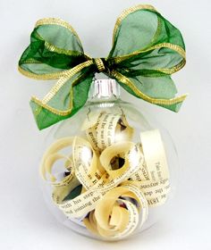 a glass ornament filled with tape and a green bow on top of it