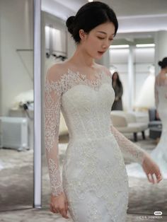 a woman in a wedding dress looking at her reflection