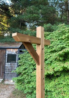 a wooden cross in front of some bushes